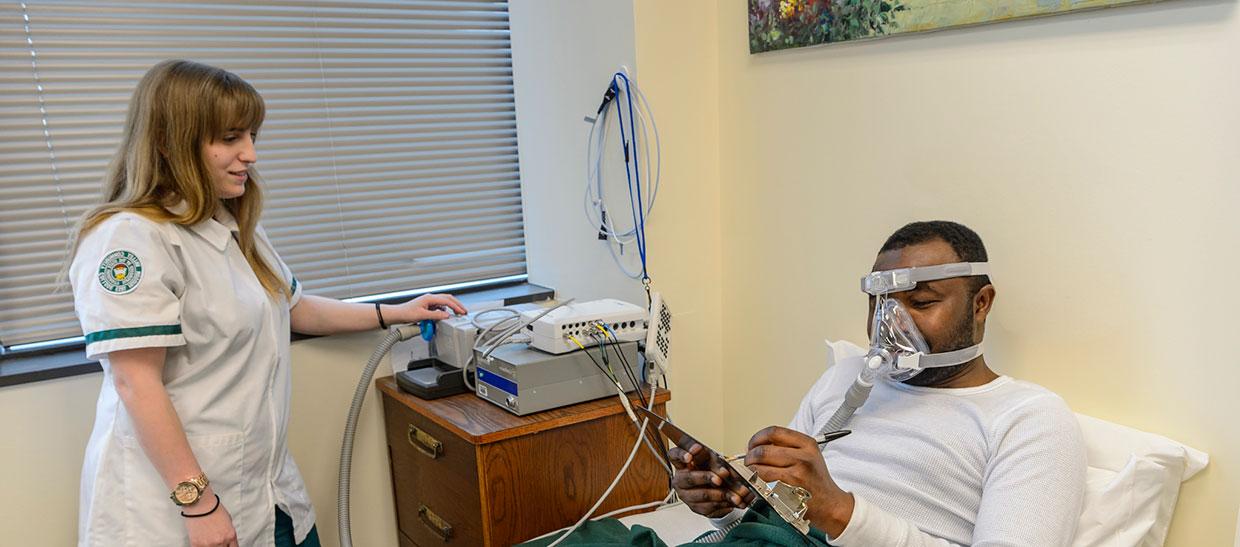 Polysomnography student with patient and sleep mask