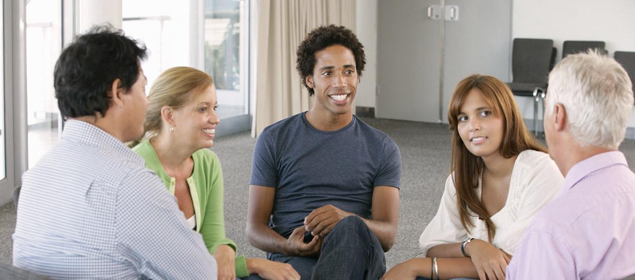 Individuals sitting in a circle at a meeting